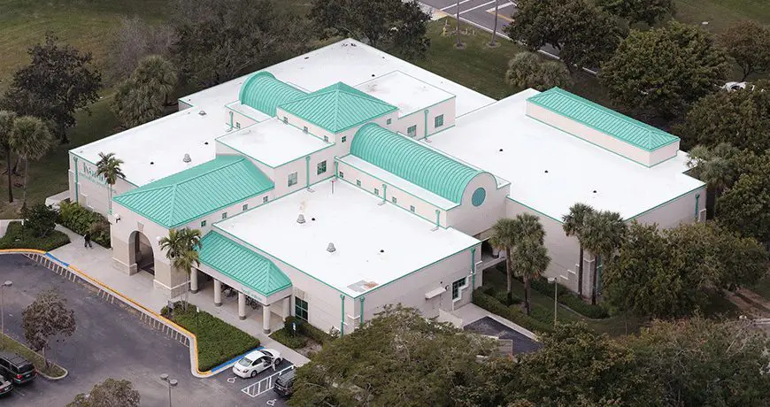 Dan-Pearl_library a white building with green metal roofing