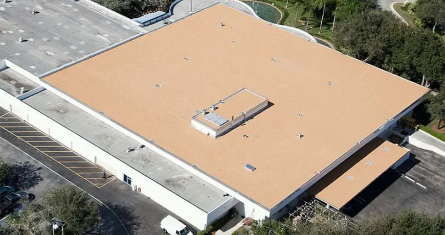 Depuy-Synthes a large commercial building with a newly installed tan-colored flat roof