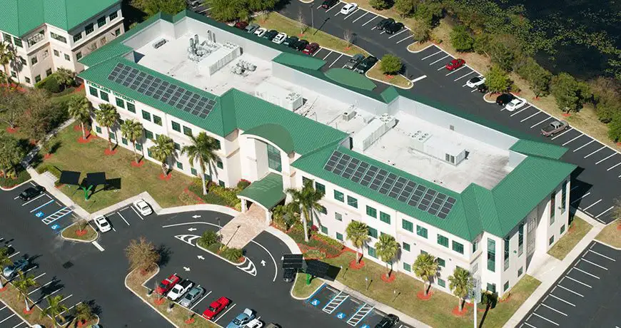 a commercial building with a green roof and solar panels in florida