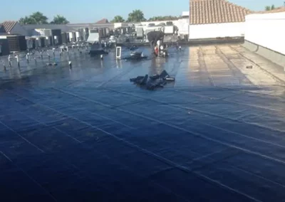 Workers installing a black waterproof membrane on a commercial roof in Palm Beach