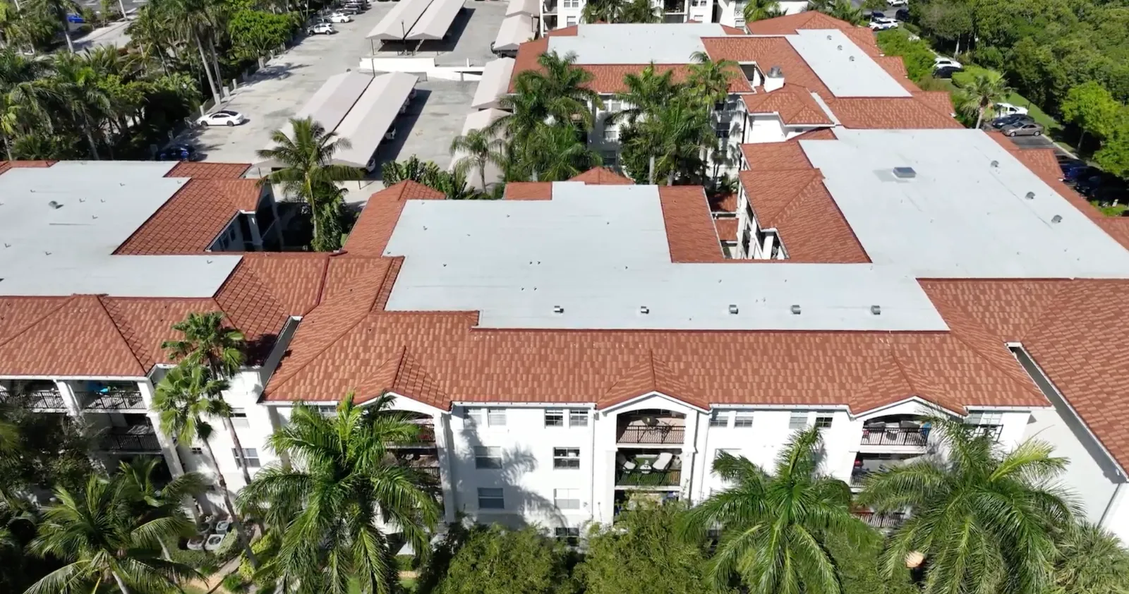 Tuscany on the Intracoastal Aerial view of Tuscany on the Intracoastal in Boynton Beach, FL showing new white flat roof sections framed by terracotta tile roofs